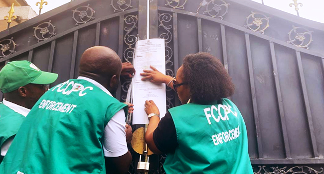 Officials of the FCCPC seal up a Chinese supermarket in Abuja